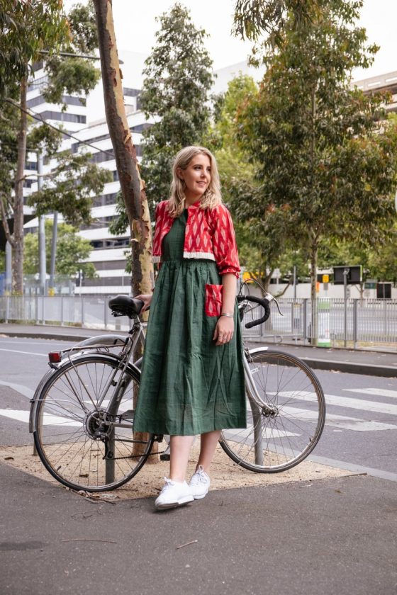 woman in red and green dress standing on road bike during daytime