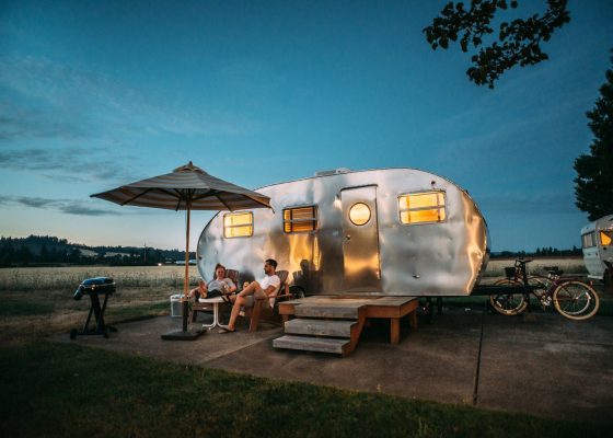 man and woman sitting in front of RV trailer